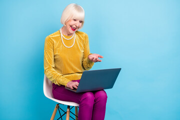 Sticker - Photo of positive short hairdo elder lady sit talk laptop wear blouse pants isolated on blue color background