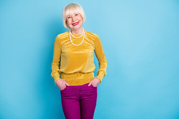 Wall Mural - Photo of optimistic short hairdo elder lady wear blouse pants isolated on blue color background