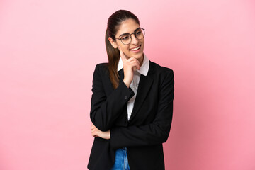 Young caucasian business woman isolated on pink background thinking an idea while looking up