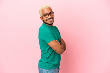 Sticker - Young Colombian handsome man isolated on pink background with arms crossed and looking forward