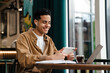 © Drobot Dean - Young hispanic man student sitting at the cafe table indoors