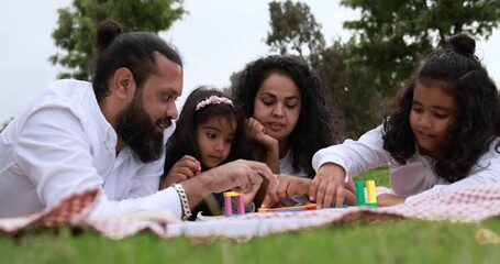 Poster - Indian parents having fun at city park playing with wood toys with their children - Family, summer and love concept 