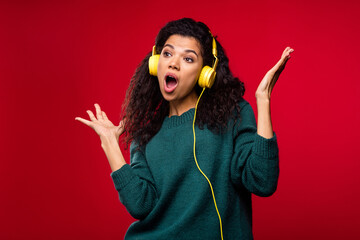 Poster - Photo of attractive nice funky afro american young woman listen music headset sing isolated on red color background