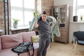 Wall Mural - Disable female with Down syndrome putting on jacket while going to fitness center for yoga class