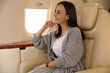 © New Africa - Young woman looking out window in airplane during flight