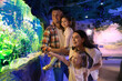 © New Africa - Happy family near aquarium in oceanarium. Spending time together