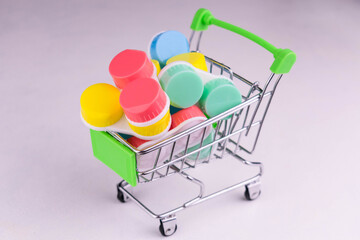 Supermarket trolley full of containers for contact lenses on a white background.