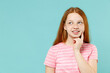 © ViDi Studio - Little pensive dreamful thoughtful redhead kid girl 12-13 years old wearing pink striped tshirt prop up chin look aside isolated on pastel blue background studio. Children lifestyle childhood concept