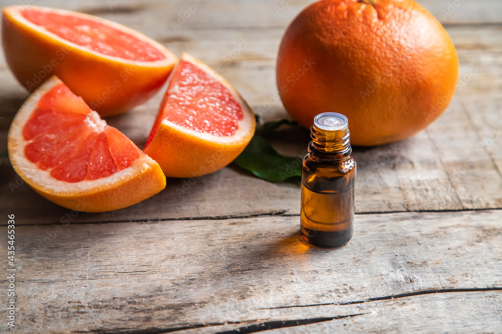 Grapefruit essential oil in a small bottle. Selective focus. - obrazy, fototapety, plakaty 