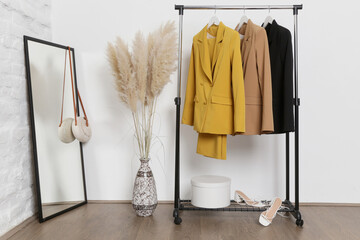 corner in fashion atelier with fashionable tailored blazers hanging on a rack. modern premium qualit