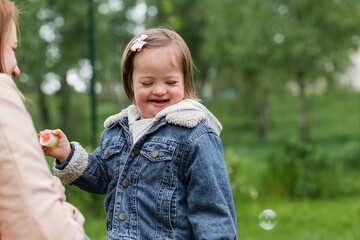 happy autistic child smiling near mother