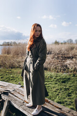 Wall Mural - Red hair girl with freckled face outdoors near the lake. Natural beauty, eco lifestyle, nature concept