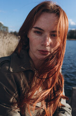 Wall Mural - Red hair girl with freckled face outdoors near the lake. Natural beauty, eco lifestyle, nature concept