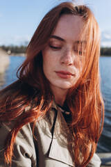 Wall Mural - Red hair girl with freckled face outdoors near the lake. Natural beauty, eco lifestyle, nature concept