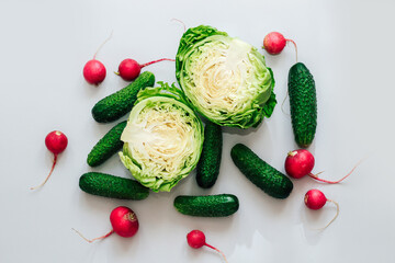 Wall Mural - Cabbage with cucumbers and radishes top view on gray background.