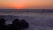 Oranger Sonnenuntergang hinter dem Meer, vorn mit Felsen bei starken Wellen - Valle Gran Rey, La Gomera mit Blick zur Insel El Hierro