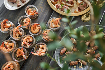 Wall Mural - Delicious fresh seafood, shrimp with fresh vegetables. buffet table with lots of delicious snacks. canapes, bruschetta, and little desserts on wooden plate board