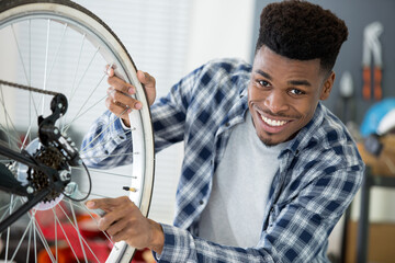 male mechanic using spanner on bicycle wheel