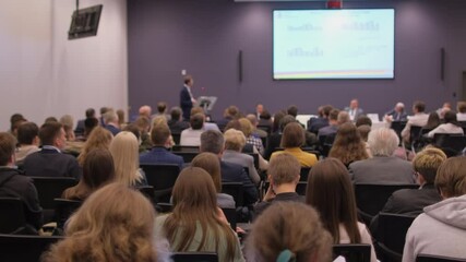 group of people listening lecture seminar of coach speaker with display screen stage. audience confe