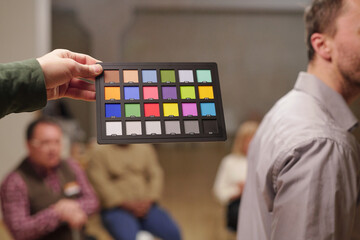 Poster - Color palette held by man against patients of psychologist sitting on chairs