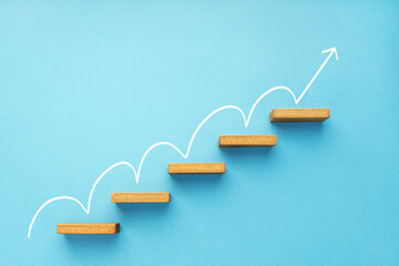 Rising arrow on staircase on blue background. Growth, increasing business, success process concept