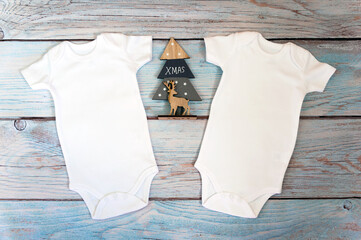 Layout Flat Put on a christmas two white baby bodysuit on a wooden background. Layout for design and placement of logos, advertising. Styled stock photography, stock photo. flat lay