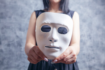 woman holding white plastic mask