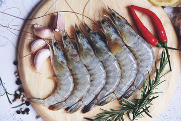 Wall Mural - Fresh shrimp seafood with herbs and spice ready for cooked food, Raw shrimps prawns on wooden plate