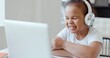 © borovikk - Afro american kid girl school pupil wearing headphones studying online from home watching web class lesson or listening tutor by video call elearning on pandemic isolation. Children remote education.