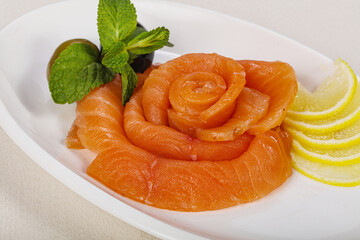 Sliced salmon snack with lemon