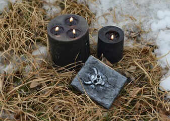 Wall Mural - Black candles and witch diary book of magic spells in grass outside.