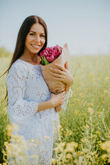 Wall Mural - Young woman in the rapeseed field