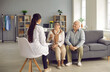 © Studio Romantic - Family doctor visiting patients at home. Young physician listening to married senior couple. Happy mature husband and wife sitting on sofa in living-room and talking to nurse or general practitioner