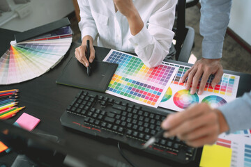 Freelance creative designer team creation project with color chart in meeting.