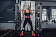 © splitov27 - Fitness woman squats with a barbell on her shoulders in dark gym. Lifestyle, bodybuilding, weightlifting and fitness