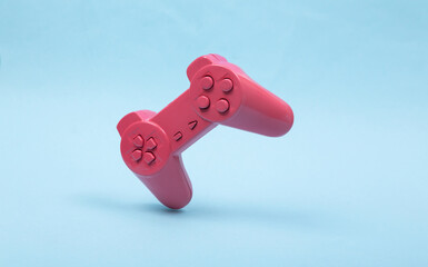 Wall Mural - Levitating pink gamepad on blue background. 3D photo. Minimalistic still life. Creative layout. Concept art