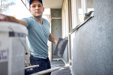 Wall Mural - Man working on a house facade.