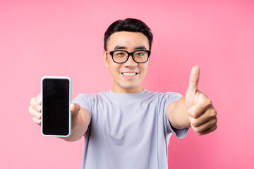 Sticker - Portrait of Asian man using smartphone on pink background