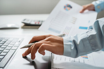 Fototapete - accountant use laptop computer with holding pen on desk in office. finance and accounting concept