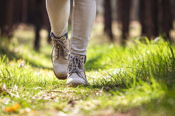 Wall Mural - hiking boot. hiker walking in forest. female legs wearing leather sports shoe in woodland