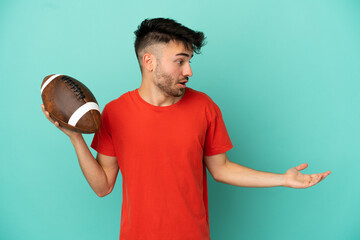 Wall Mural - Young Caucasian man playing rugby isolated on blue background with surprise expression while looking side