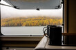 canvas print picture - Camping Pause Kaffee Tee Tasse mit Blick aus dem Fenster auf See und herbstlichen Wald