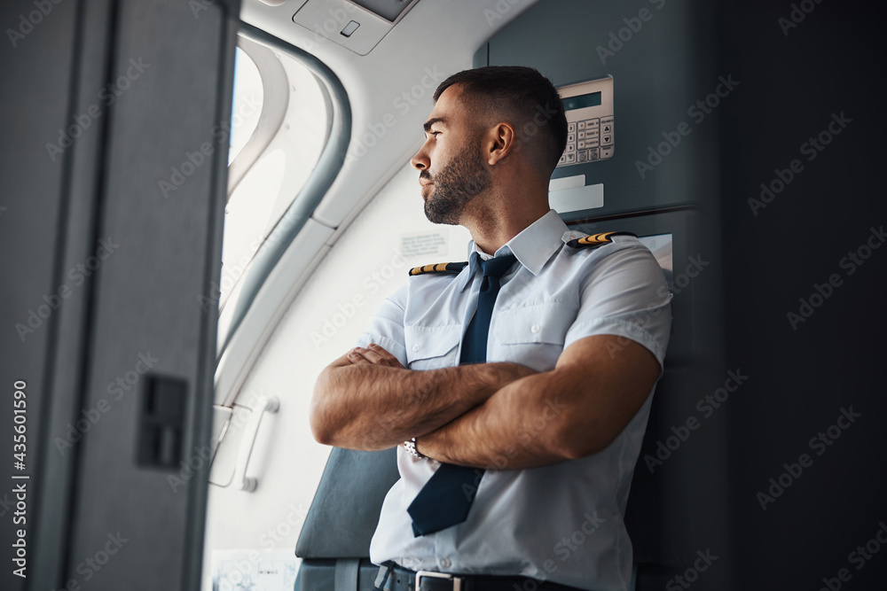 Curious pilot checking the weather before the flight - obrazy, fototapety, plakaty 