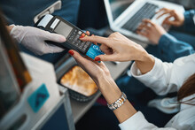 Person entering her card number on POS terminal on plane