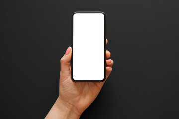 Person holding phone in one hand on dark background