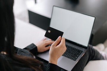 Woman with credit card using laptop, closeup