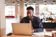 © Monkey Business - Young Businessman Sitting At Desk With Laptop In Modern Open Plan Office