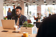 © Monkey Business - Young Businessman Sitting At Desk With Laptop In Modern Open Plan Office