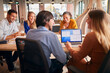 © Monkey Business - Business Team Having Meeting Sitting Around Table In Modern Open Plan Office