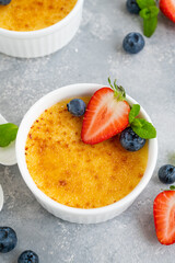 creme brulee. traditional french vanilla cream dessert with caramelised sugar and fresh berries on t